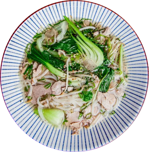 Phở bò mit Rindfleisch, Pak Choi und Reisnudeln in einer blau gestreiften Schale, von oben